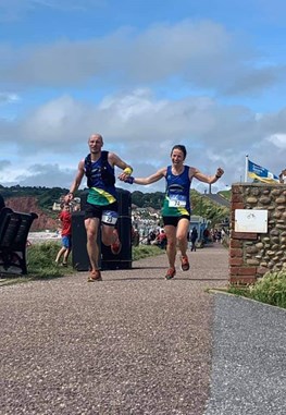 debbie proctor and ben elphick cross the line hand in hand at exe estuary half marathon.jpeg