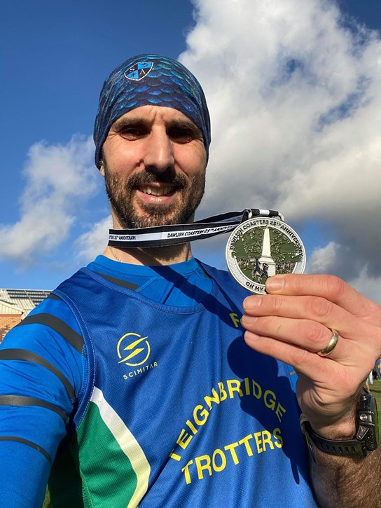 andrew fox proudly shows off his medal.jpeg